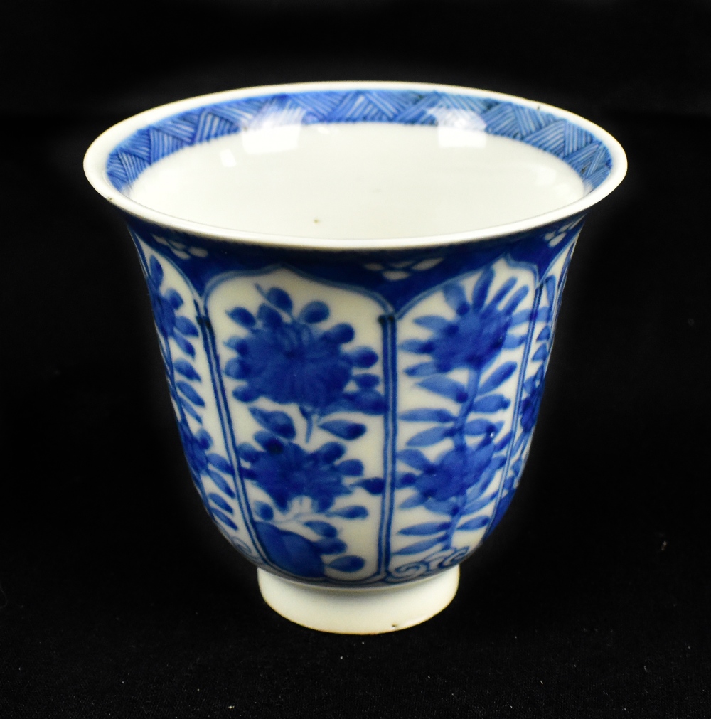 A Chinese blue and white tapering cup decorated with panels of floral sprays and painted six