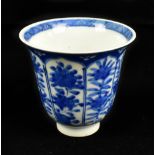 A Chinese blue and white tapering cup decorated with panels of floral sprays and painted six