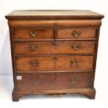 A George III oak chest with frieze drawer above two short and three long drawers on ogee bracket