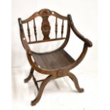 A reproduction Savonarola chair with spindle and carved back above panelled seat (af).