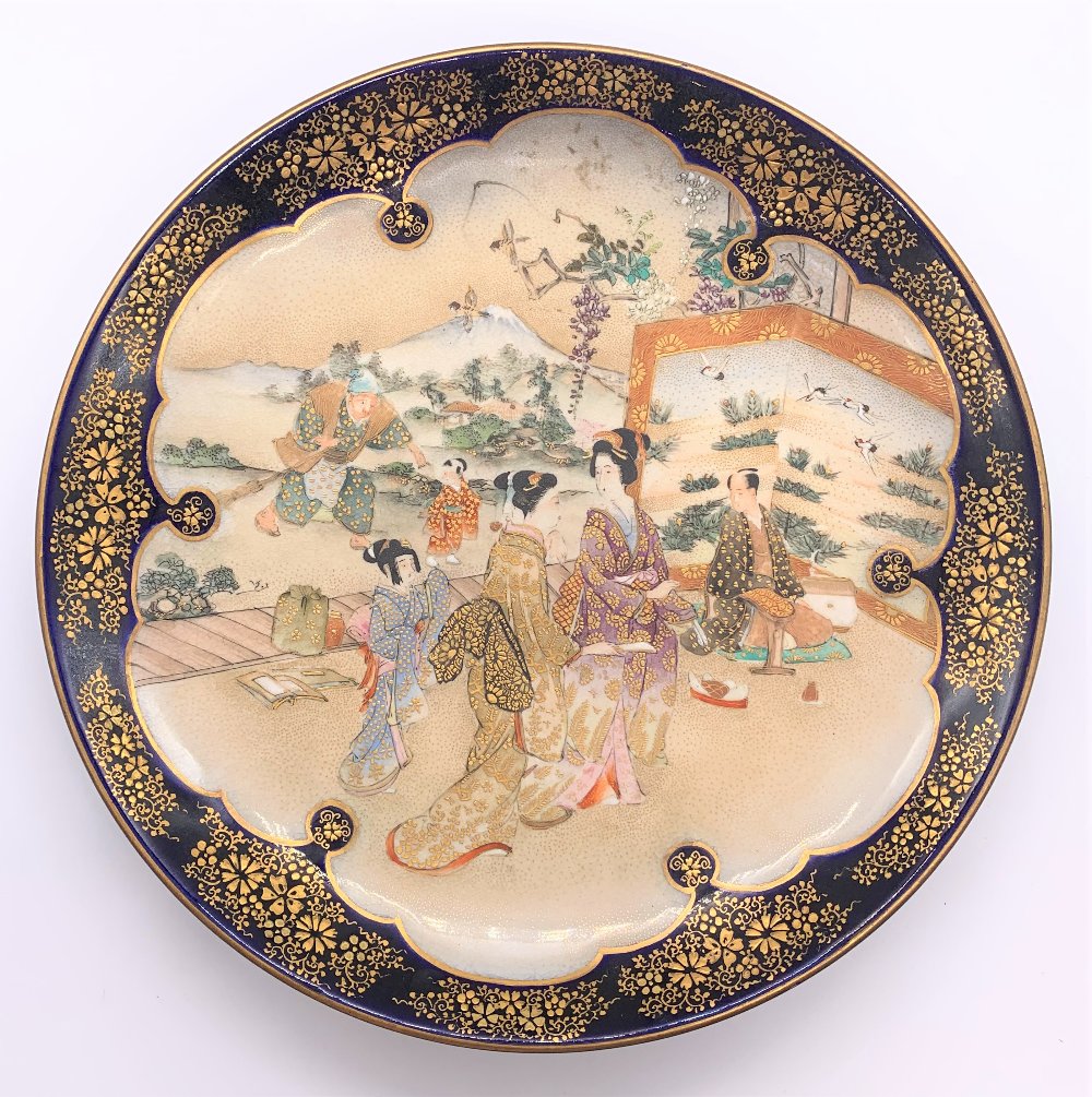 A Japanese Meiji period Satsuma plate with cobalt blue border and central panel of figures with