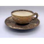 KINKOZAN; a Japanese Meiji period Satsuma cup and saucer decorated with panels of seated figures