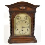 KIENZLE; a circa 1900 German oak cased mantel clock, the silvered dial set with Arabic numerals,