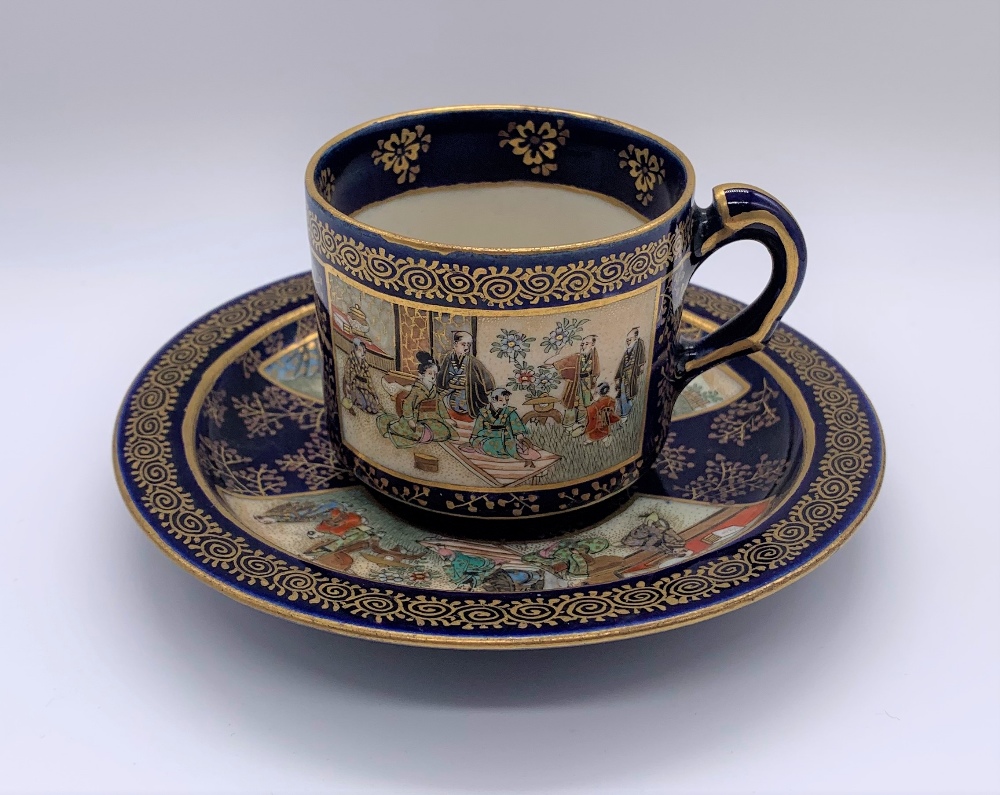 KINKOZAN; a Japanese Meiji period Satsuma cup and saucer decorated with panels of seated figures