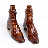 A pair of 19th century treacle glazed flasks modelled as lady's boots with buttons to the side and