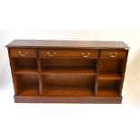 A reproduction mahogany veneered bookcase with three drawers above three adjustable shelves,