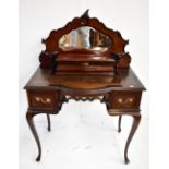 An Edwardian mahogany lady's writing desk with carved mirror back, fitted stationery box and gilt