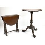 A reproduction mahogany pie crust tilt top occasional table raised on knee carved legs to ball and