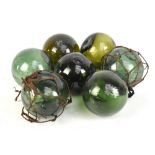 Seven green glass vintage fishing floats, two retaining rope frames, diameter approx 12cm.Additional