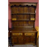 A 18th Century style reproduction medium oak canopy dresser, the top section with two fixed