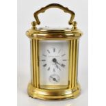 MATTHEW NORMAN; a brass cased carriage clock of oval form, the dial with Roman numerals and