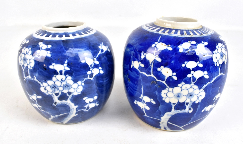 Two similar early 20th century Chinese blue and white prunus decorated jars, height 14cm and 13cm,