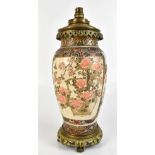 An early 20th century Japanese Satsuma oil lamp with brass mount, painted with birds and flowers,