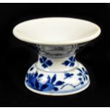 A Chinese blue and white floral decorated scholar's candle holder with conical shaped well and