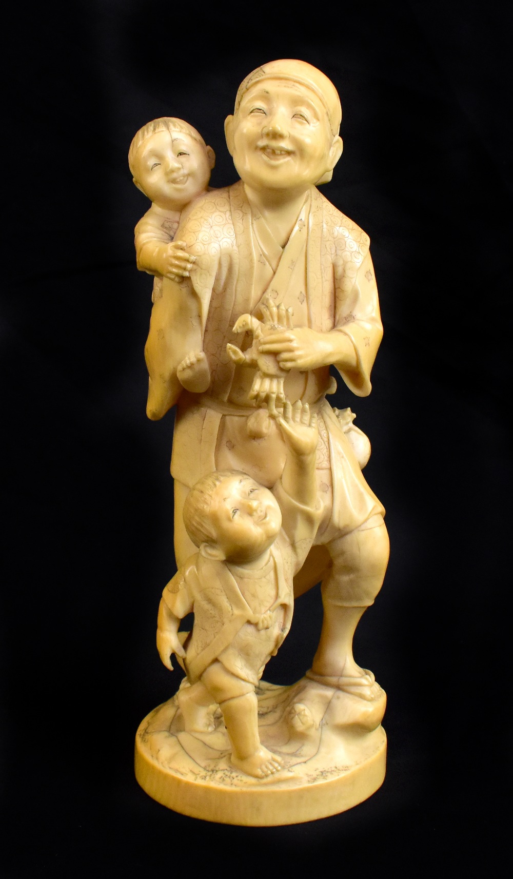 TOKYO SCHOOL; a good Japanese Meiji period carved ivory okimono modelled as a man holding a crab