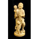TOKYO SCHOOL; a good Japanese Meiji period carved ivory okimono modelled as a man holding a crab