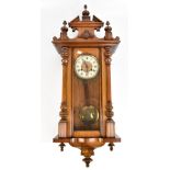 An early 20th century stained beech Vienna style wall clock, length 105cm, complete with key and