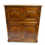 A reproduction oak drinks cabinet with two panelled doors above slide and two further doors raised