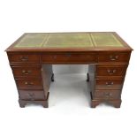 A reproduction mahogany veneered knee hole desk with leather inset top above an arrangement of six