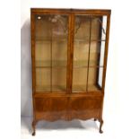 A walnut and burr walnut display cabinet, the twin glazed doors enclosing two glass shelves above