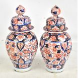 A pair of Japanese Meiji period Imari ribbed lidded vases with underglaze and gilt floral