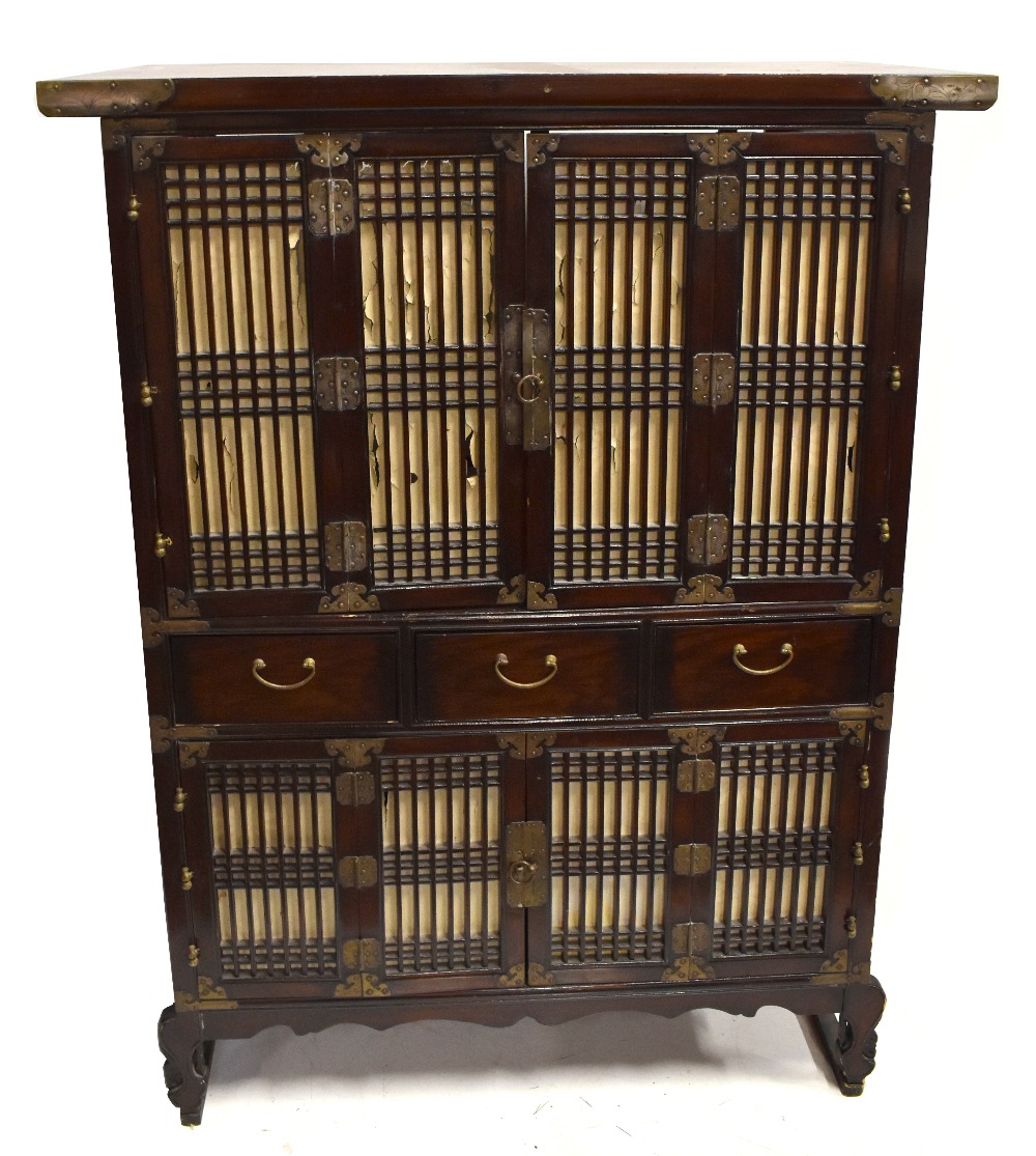 A Chinese hardwood 'chicken coop' cabinet with pierced panels and foliate detailed metal mounts,