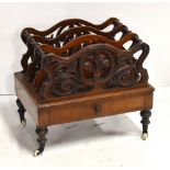 A Victorian walnut four division Canterbury with pierced floral decoration and single base drawer,