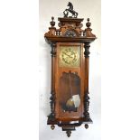 A 19th century Vienna style wall clock, the brass face with Roman numerals, with carved eagle