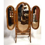 A folding three panel cheval mirror with carved detail on outswept supports, height 179cm, width