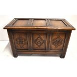 A small reproduction oak coffer with carved detail to the three panel front, height 44.5cm, width