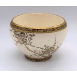 A Japanese Meiji period Satsuma bowl with twin Greek key borders and cream ground body decorated