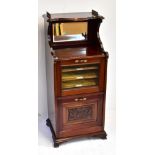 An Edwardian mahogany music cabinet with part galleried top and mirror back shelf above glazed