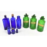 A group of green and blue glass pharmacist/chemist bottles, the three green examples with gilt