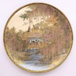 A fine Japanese Meiji period Satsuma plate decorated with figures on a bridge within cascades of