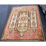 A very large Middle Eastern rug with stylised floral detail on pink ground, 250 x 335cm.Additional