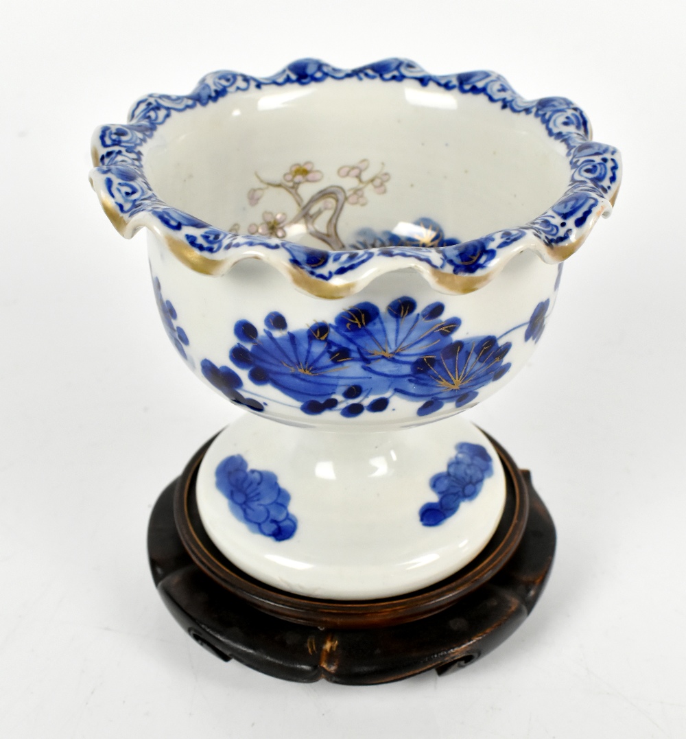 A Japanese porcelain pedestal bowl painted in underglaze blue with floral detail to interior and