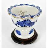 A Japanese porcelain pedestal bowl painted in underglaze blue with floral detail to interior and