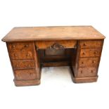 A Victorian walnut and figured walnut veneered nine drawer pedestal desk, with carved detail to