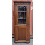 A late 19th century mahogany free standing corner cabinet with blind fret detail to the top