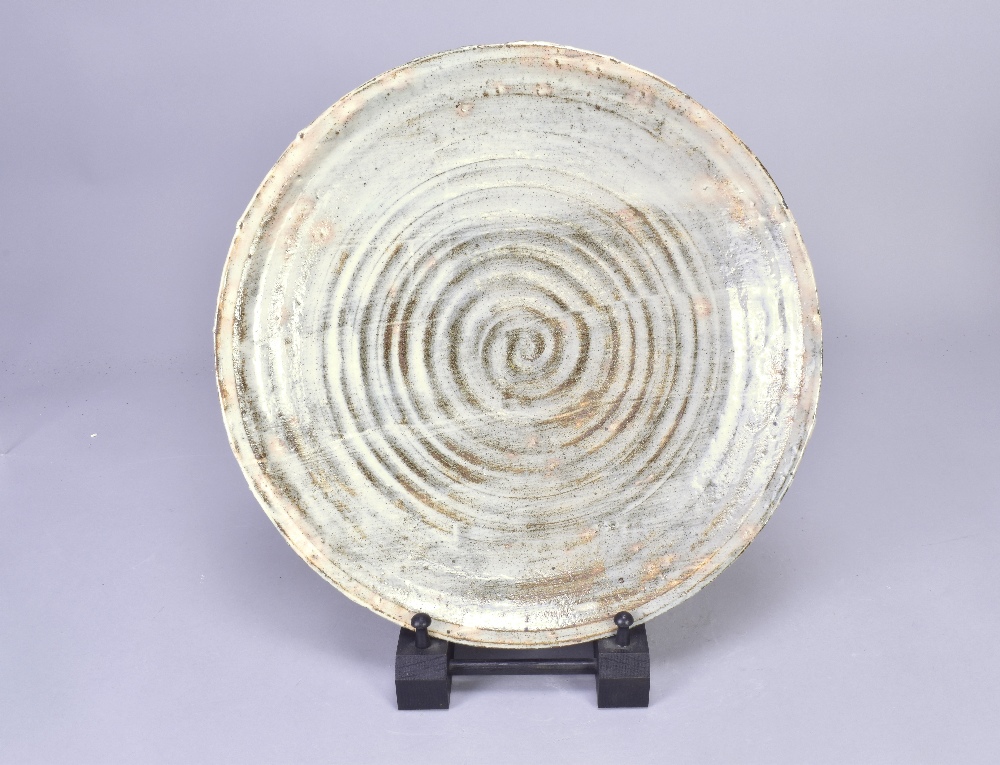 AKIKO HIRAI (born 1970); a stoneware platter covered in pale grey glaze with pink blushes,