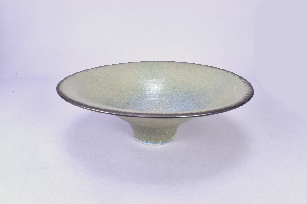 ABDO NAGI (1941-2001); a stoneware pedestal bowl covered in mottled green glaze with bronze rim,