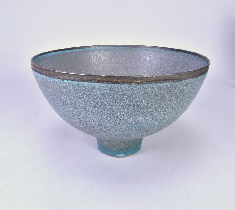 ABDO NAGI (1941-2001); a stoneware pedestal bowl covered in mottled blue glaze with bronze rim, made