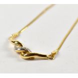 A yellow metal twist pendant, set with white sapphire and suspended on a yellow metal fine link