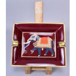 HERMES; a burgundy and gold coloured porcelain cigar ashtray featuring an Indian elephant (