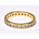 A yellow metal diamond set full eternity ring with channel set round brilliant cut stones, size I,