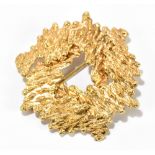 A 9ct yellow gold textured 1970s style brooch, diameter approx 35mm, approx 4.4g.Additional