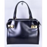 SALVATORE FERRAGAMO; a black leather handbag with detachable shoulder strap and gold tone logo