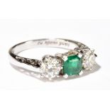 A platinum emerald and diamond three stone ring, the central square cut emerald in four claw mount