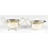 J S; a George V hallmarked silver twin handled sugar bowl and cream jug both with crimped rims,