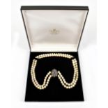 A yellow and white metal clasped pearl necklace set with sapphires and melee diamonds, stamped